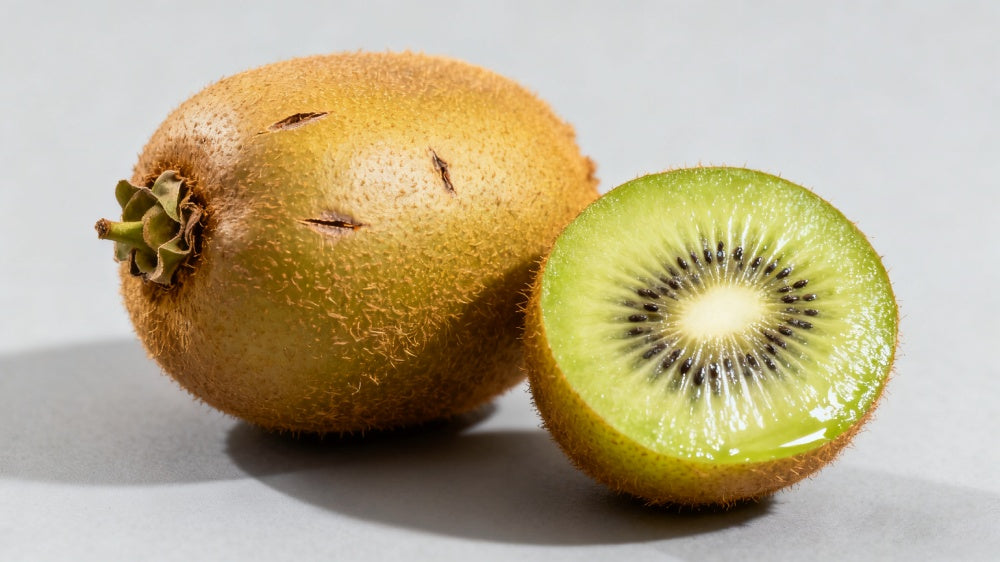 Whole and halved kiwi fruit on a light gray background APEXEL