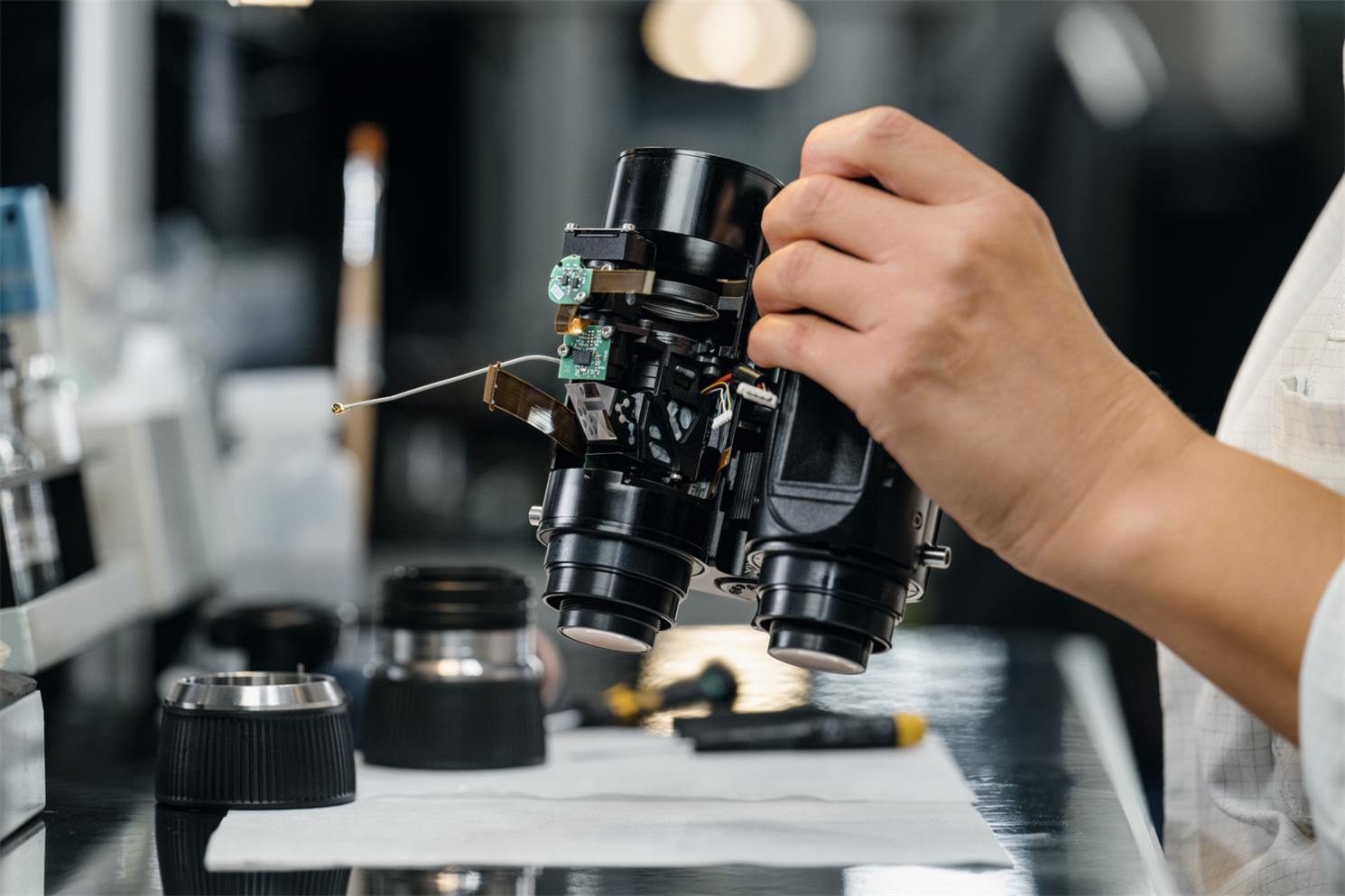 A technician is holding a new Apexel telescope and debugging it.